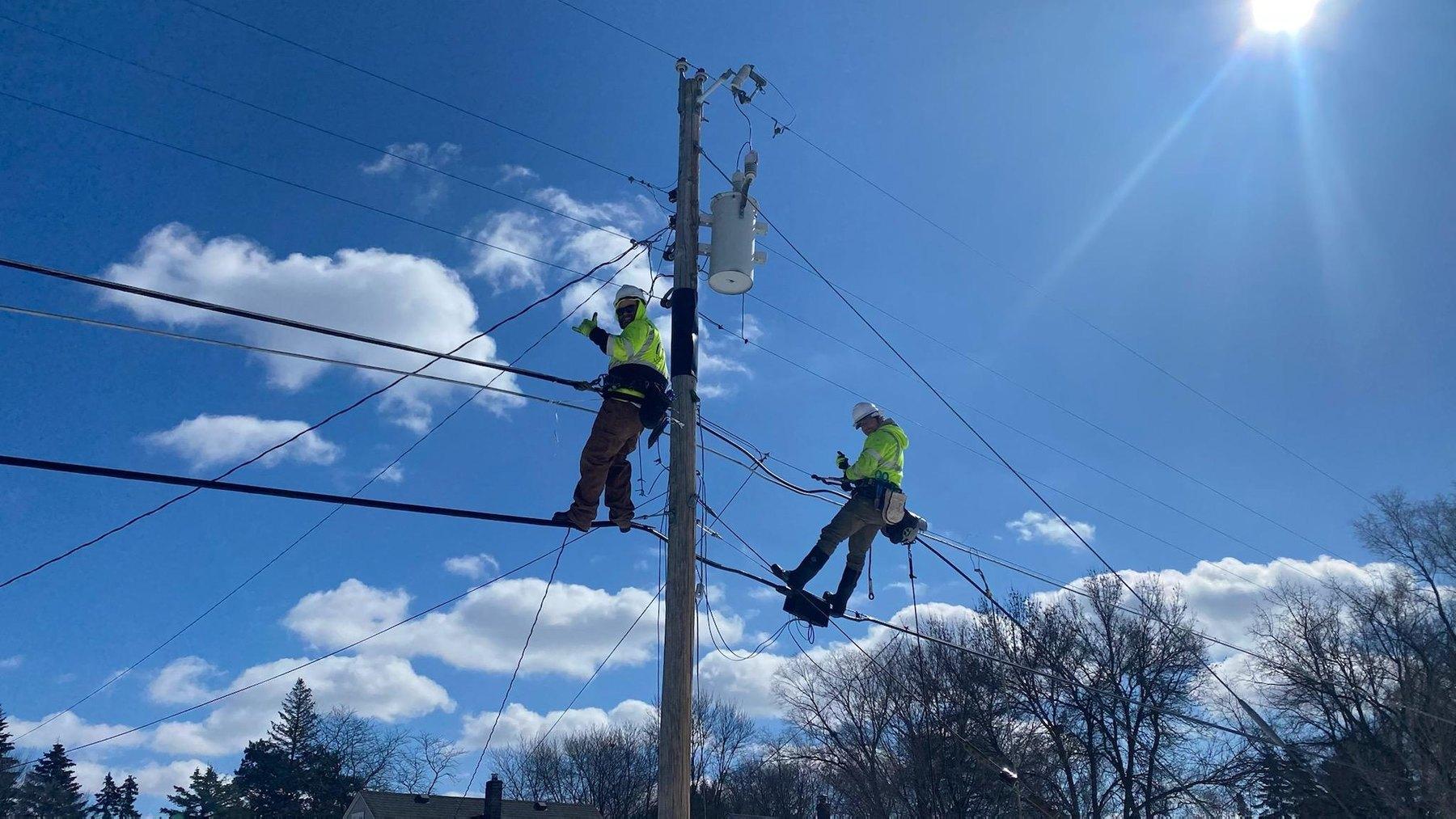 MCI crew members working on a utility pole with a transformer