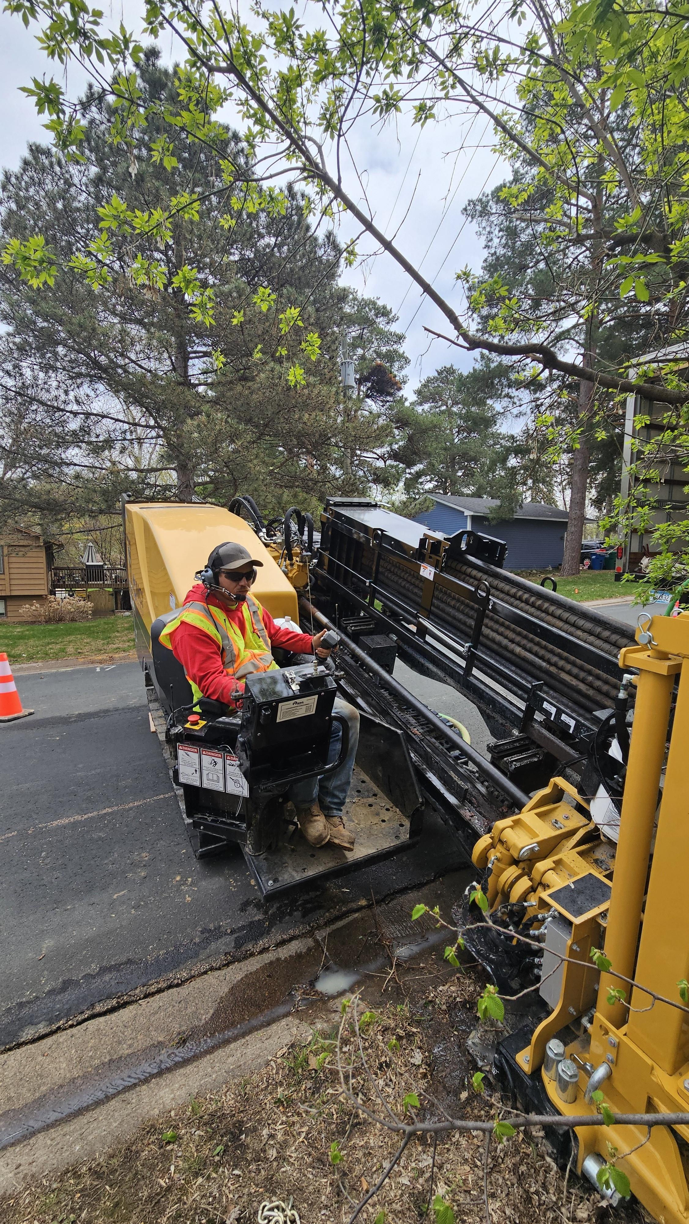 MCI operator seated at HDD rig controls on a residential street