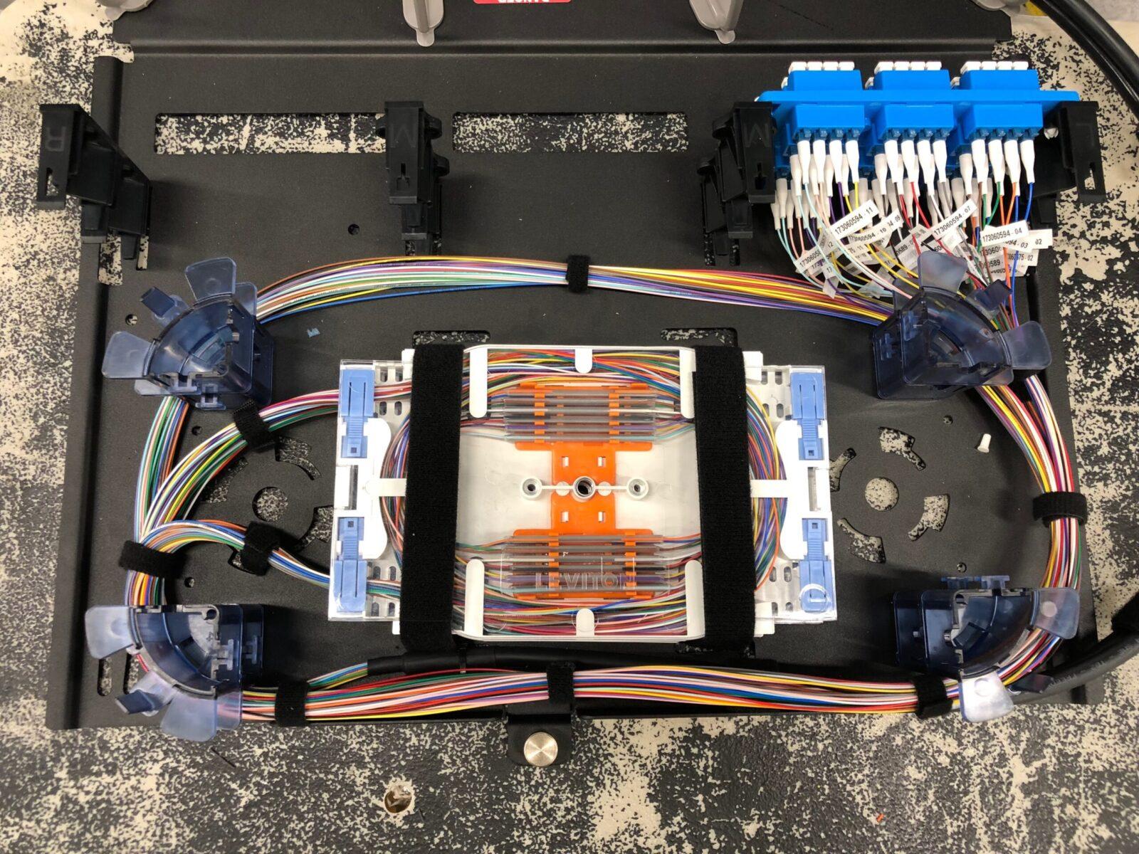 Overhead view of an open fiber splice enclosure with organized trays